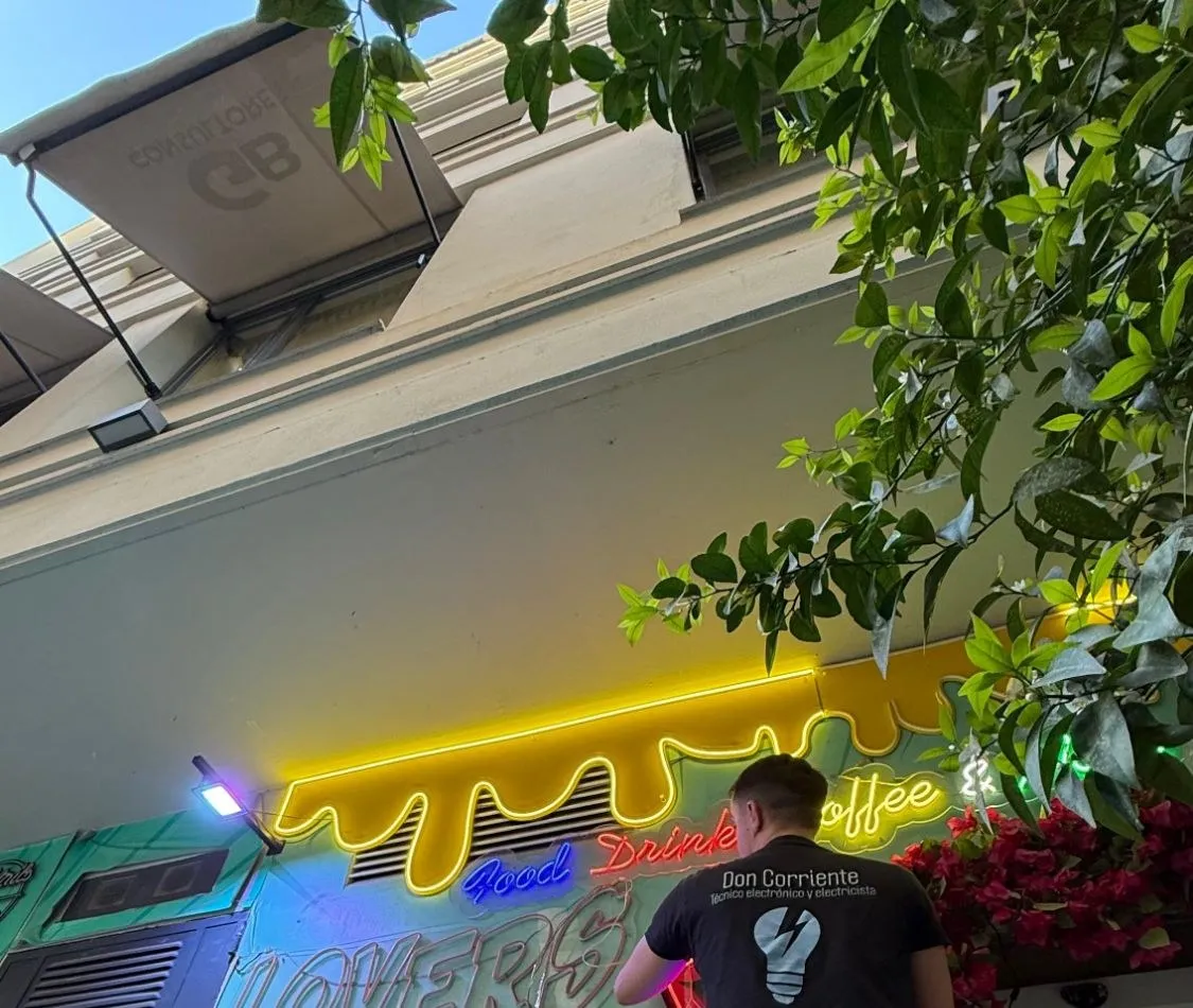 Electricista de Don Corriente instalando el rótulo de neón LED de una cafetería